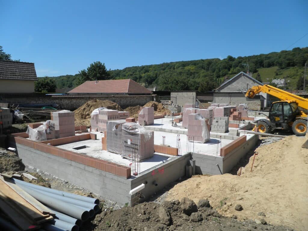 Fondations coulées et palettes de briques alvéolaires sur le chantier