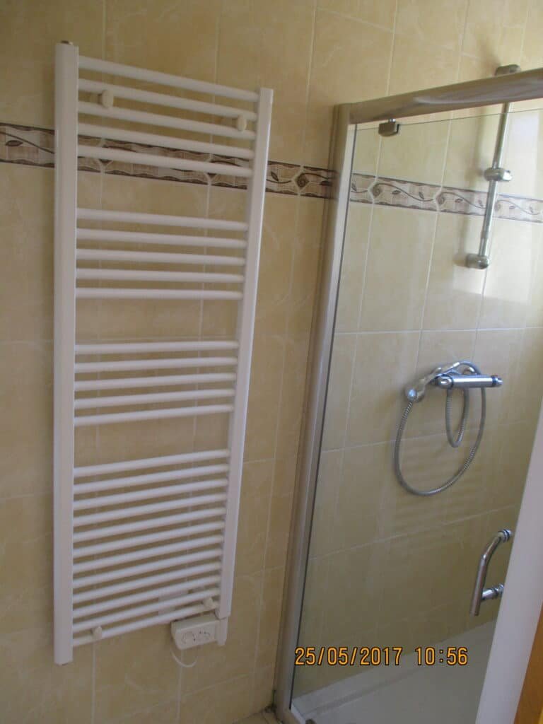 Salle de bain avec douche vitrée et sèche-serviettes